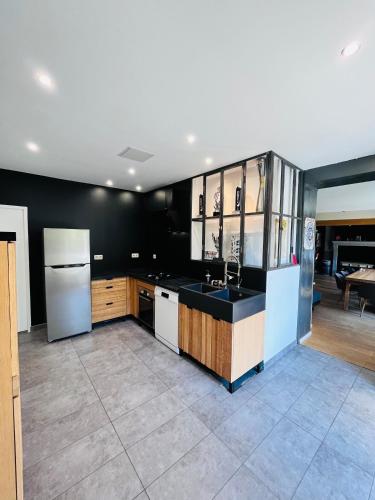 une cuisine avec un évier et un réfrigérateur dans l'établissement Maison 1440 - SPIRIT, logement Atypique Sport Auto, à Saint-Gervais en-Belin