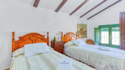 Ένα ή περισσότερα κρεβάτια σε δωμάτιο στο Cortijo San León Fuente de Piedra by Ruralidays