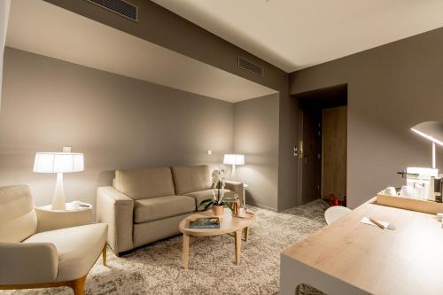 a living room with a couch and a table at Dolce by Wyndham Versailles - Domaine du Montcel in Jouy-en-Josas
