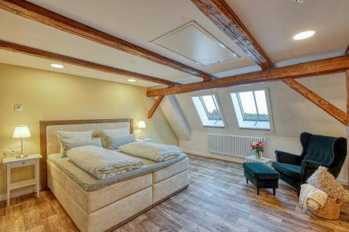 a bedroom with a large bed and two chairs at Ferienwohnungen Steinweg 61 in Quedlinburg