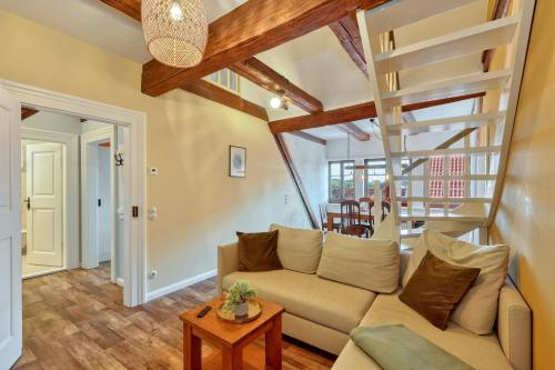a living room with a couch and a staircase at Ferienwohnungen Steinweg 61 in Quedlinburg