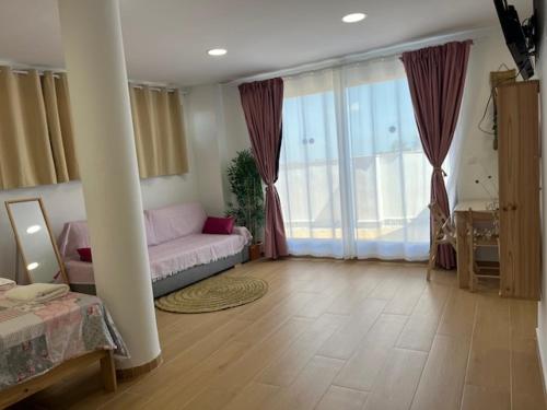 a living room with a couch and a large window at ALZIRA BONITA Apto con terraza y cama balinesa les barraques in Alzira