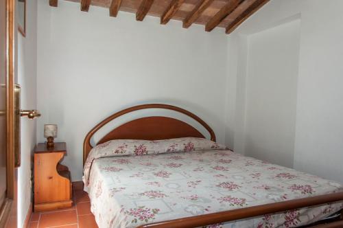 a bedroom with a bed with a wooden headboard at Sant'Antonio in Volterra