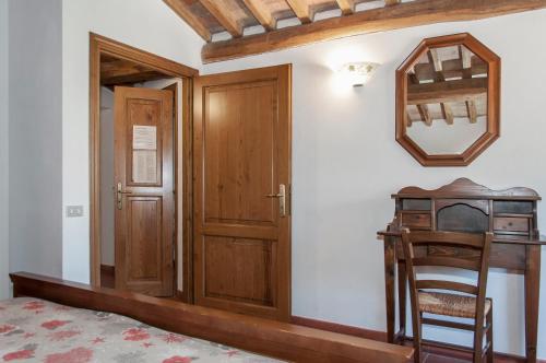a bedroom with a wooden door and a desk at Sant'Antonio in Volterra