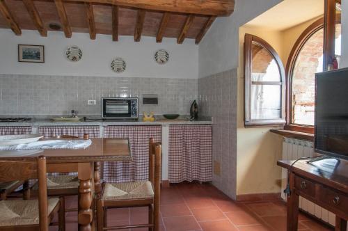 a kitchen with a table and a microwave at Sant'Antonio in Volterra