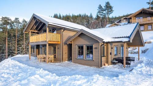 a log home in the snow with a deck at Gandalv Hytte - 8p - With Sauna & Hot Tub in Vradal