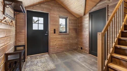 a tiny house with a black door and wooden walls at Gandalv Hytte - 8p - With Sauna & Hot Tub in Vradal