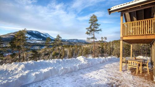 a porch of a cabin with a table in the snow at Gandalv Hytte - 8p - With Sauna & Hot Tub in Vradal