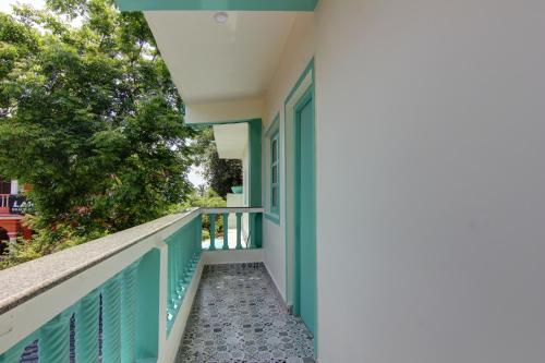 a balcony of a house with blue shutters at Comfort Holiday Home in Baga