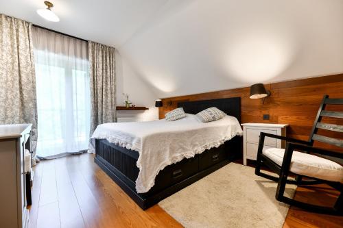 a bedroom with a bed and a chair and a window at Villa VEGA - Gorseti in Gornji Šajn