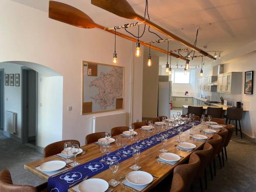 a long table with plates and wine glasses on it at Abergwaun Cottage in Fishguard
