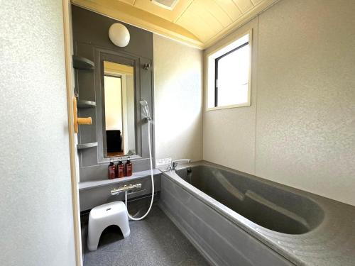 a bathroom with a large tub and a sink at The CATAN 石垣島 in Nagura