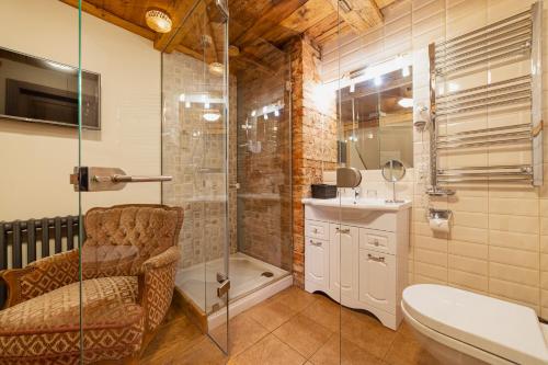 a bathroom with a shower and a toilet and a sink at Boutique Hotel Virkas muiža in Kuldīga