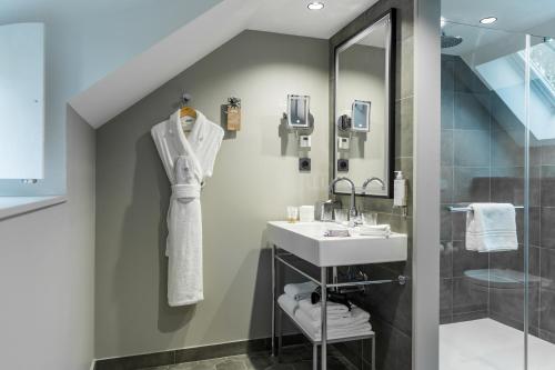 a bathroom with a sink and a shower at Dolce by Wyndham Versailles - Domaine du Montcel in Jouy-en-Josas