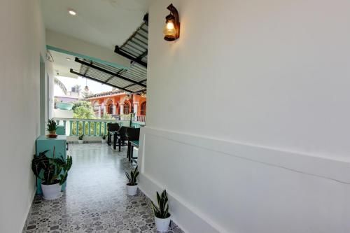 a hallway with potted plants in a building at Comfort Holiday Home in Baga