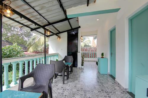 a patio with chairs and tables on a balcony at Comfort Holiday Home in Baga