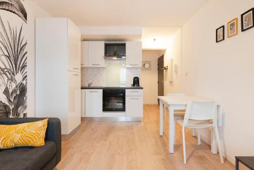 une cuisine et un salon avec une table et des chaises dans l'établissement Le Parfait de Jean Lamour - avec parking privé, à Nancy