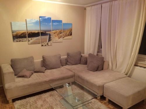 a living room with a couch and some paintings at Cityapartment An der Petrikirche in Braunschweig