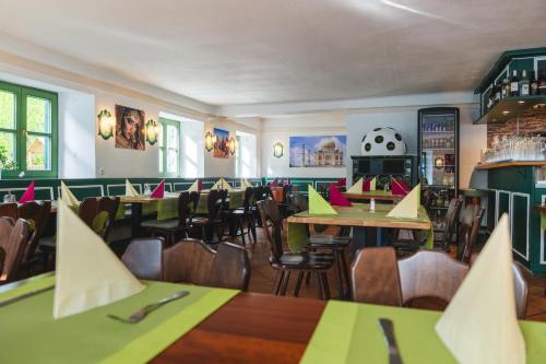 a dining room with tables and chairs and a soccer ball on the wall at Hotel Restaurant Taverna in Eching