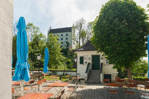 a patio with tables and chairs with umbrellas at Hotel Restaurant Taverna in Eching