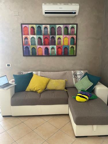 a couch in a living room with a painting on the wall at Piccolo Paradiso in Praia a Mare in Praia a Mare