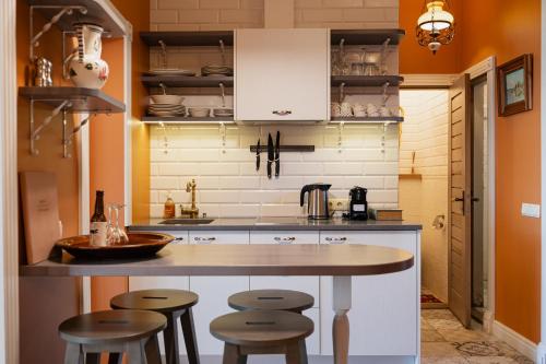 a kitchen with a counter and stools in it at Boutique Hotel Virkas muiža in Kuldīga