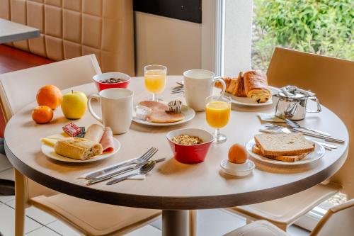 a breakfast table with breakfast foods and drinks on it at Ace Hotel Arras-Beaurains in Beaurains