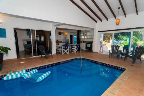a swimming pool in a house with a living room at Hodges Bay House in Calibishie