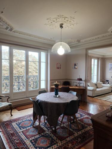 un salon avec une table et des chaises dans l'établissement Appartement Haussmannien, à Charenton-le-Pont