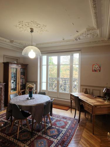 une salle à manger avec une table et une fenêtre dans l'établissement Appartement Haussmannien, à Charenton-le-Pont