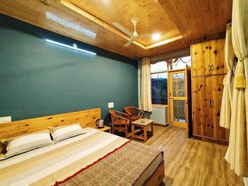 a bedroom with a large bed and a green wall at Rustic Roots Home Stay in Nagar