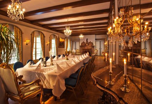 a dining room with tables and chairs and chandeliers at Villa Lovik in Lidingö