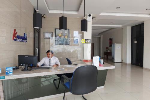 a man sitting at a desk with a computer at Kanasha Islami in Medan