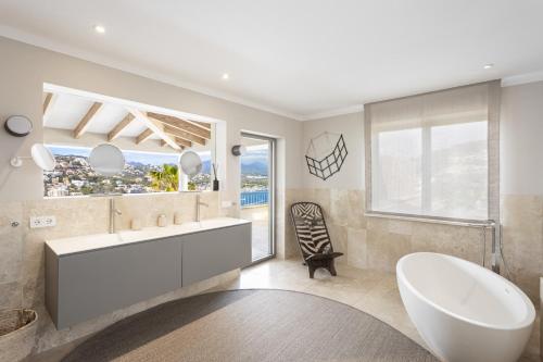 a bathroom with a tub and a sink and a window at Villa Mimosa in Andratx