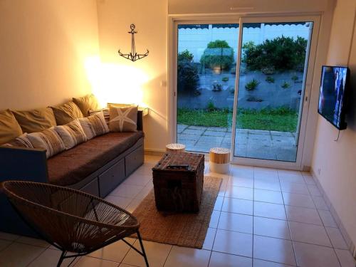 a living room with a couch and a table at Erquy, vue mer, centre, plages & commerces a pieds in Erquy