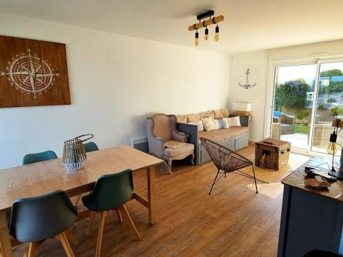 a living room with a table and chairs and a couch at Erquy, vue mer, centre, plages & commerces a pieds in Erquy