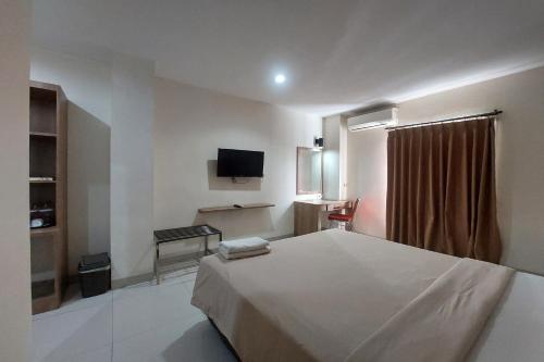 a hotel room with a bed and a television at Kanasha Islami in Medan