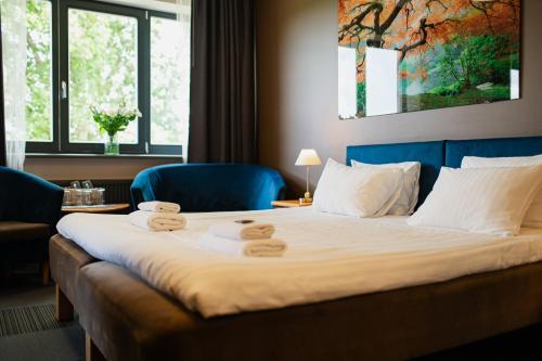 a hotel room with a bed with two towels on it at Comfort Hotel Kuldiga in Kuldīga