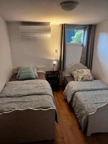 a bedroom with two beds and a window at edendebruges in Bruges