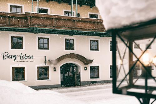 a white building with a black door in the snow at Berg-Leben in Grossarl