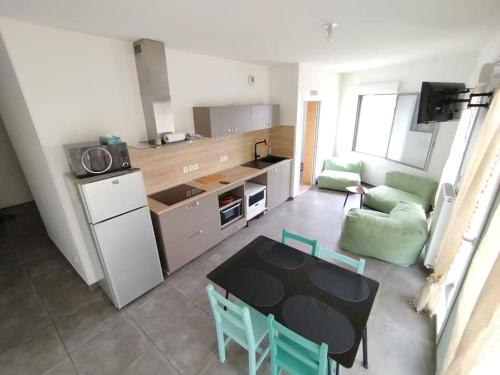 un salon avec une table et une cuisine dans l'établissement HOMEYPIC Villeurbanne T4 proche INSA, à Villeurbanne