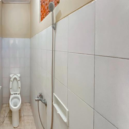 a bathroom with a shower and a toilet at RedDoorz near Taman Bunga Nusantara in Pasirhuni