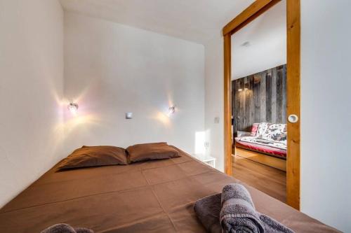 a bedroom with a large bed and a mirror at Jardins de Val Le charme à la Montagne in Val dʼIsère