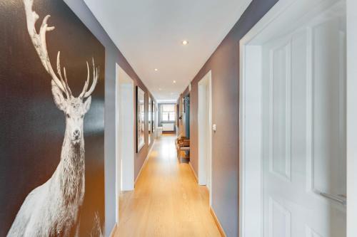 a hallway with a painting of a deer on the wall at Design Apartment Villa Anna Kitzbühel in Kitzbühel