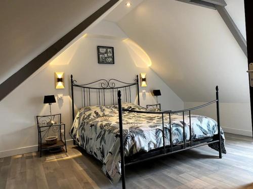 - une chambre mansardée avec un lit noir dans l'établissement Belle maison proche St Malo #Vacances En Bretagne, à Miniac-Morvan