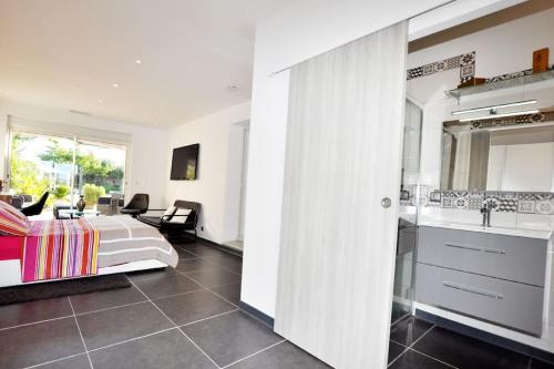 une chambre avec un lit et une salle de bain avec un lavabo dans l'établissement Villa de rêve à Pia - Piscine et 4 terrasses, à Pia