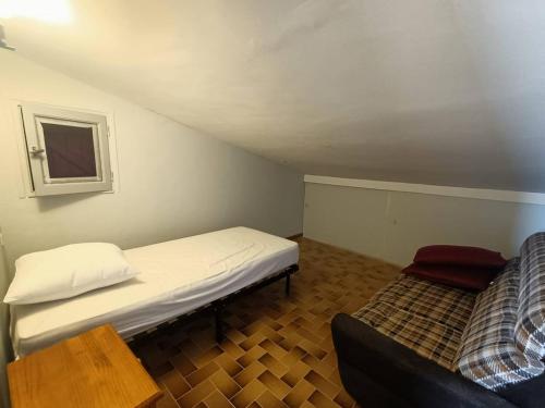 mały pokój z łóżkiem i kanapą w obiekcie Maison de Famille Vintage à 100m de la Plage 10ARGO82 w mieście Saint Pierre La Mer