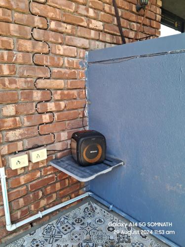 a tv sitting on a shelf next to a brick wall at Luxury Villa Ganga Kutir in Raichak