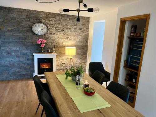 a dining room with a table and a fireplace at Green House in Stara Sušica
