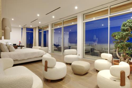 - une chambre dotée d'un mobilier blanc et d'une grande fenêtre dans l'établissement Tigliola Resort, à Porto-Vecchio